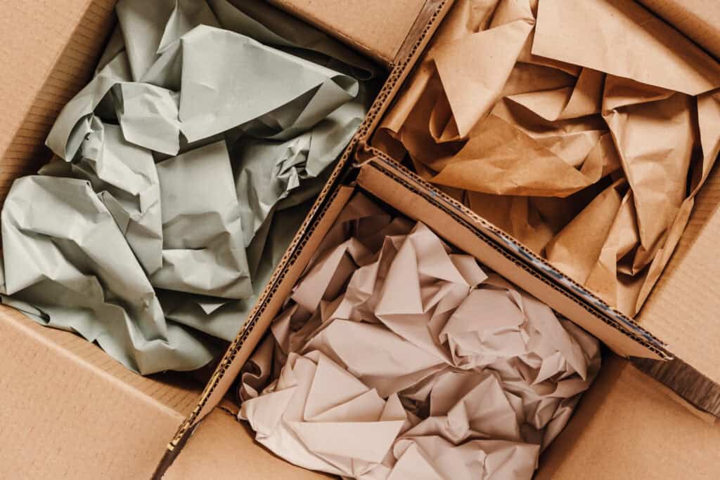 Cardboard boxes with crumpled paper inside for packaging goods.