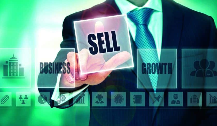 A businessman pressing a sell button on a transparent screen.