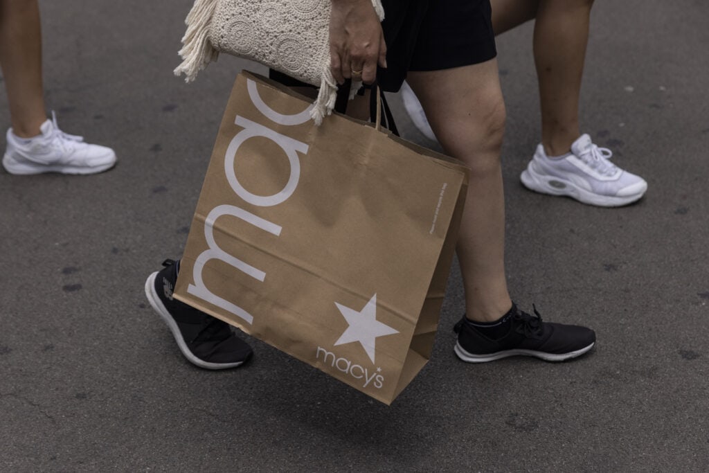 Shoppers and pedestrians pass by Macys Herald Square in New York