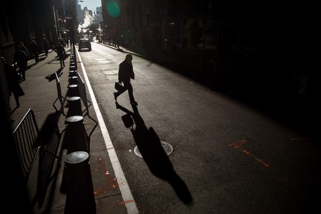 Pedestrians walk along Wall Street near the New York Stock Exchange