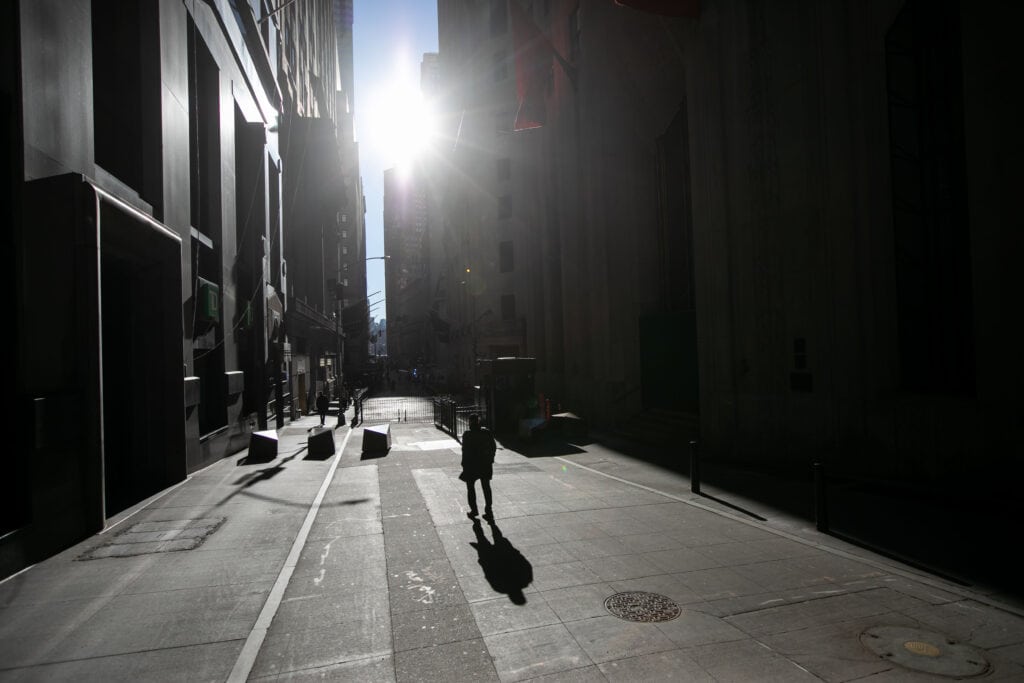Pedestrians walk along Wall Street near the New York Stock Exchange