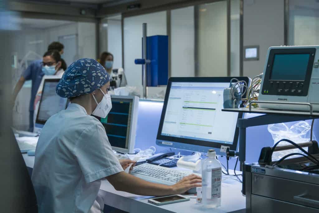 A nurse works with the computer in the ICU