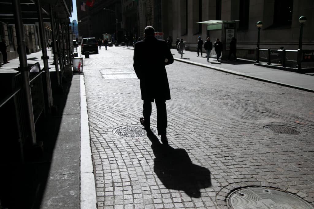 A pedestrian walks along Wall Street near the New York Stock Exchange