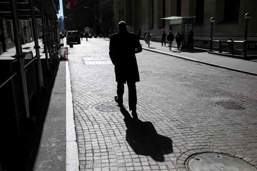 A pedestrian walks along Wall Street near the New York Stock Exchange