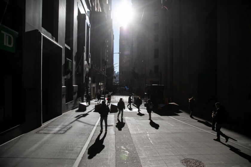 Pedestrians walk along Wall Street near the New York Stock Exchange