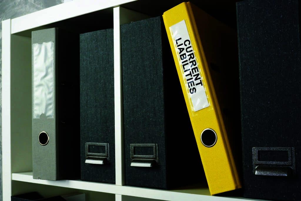 Office shelf with yellow folder current liabilities