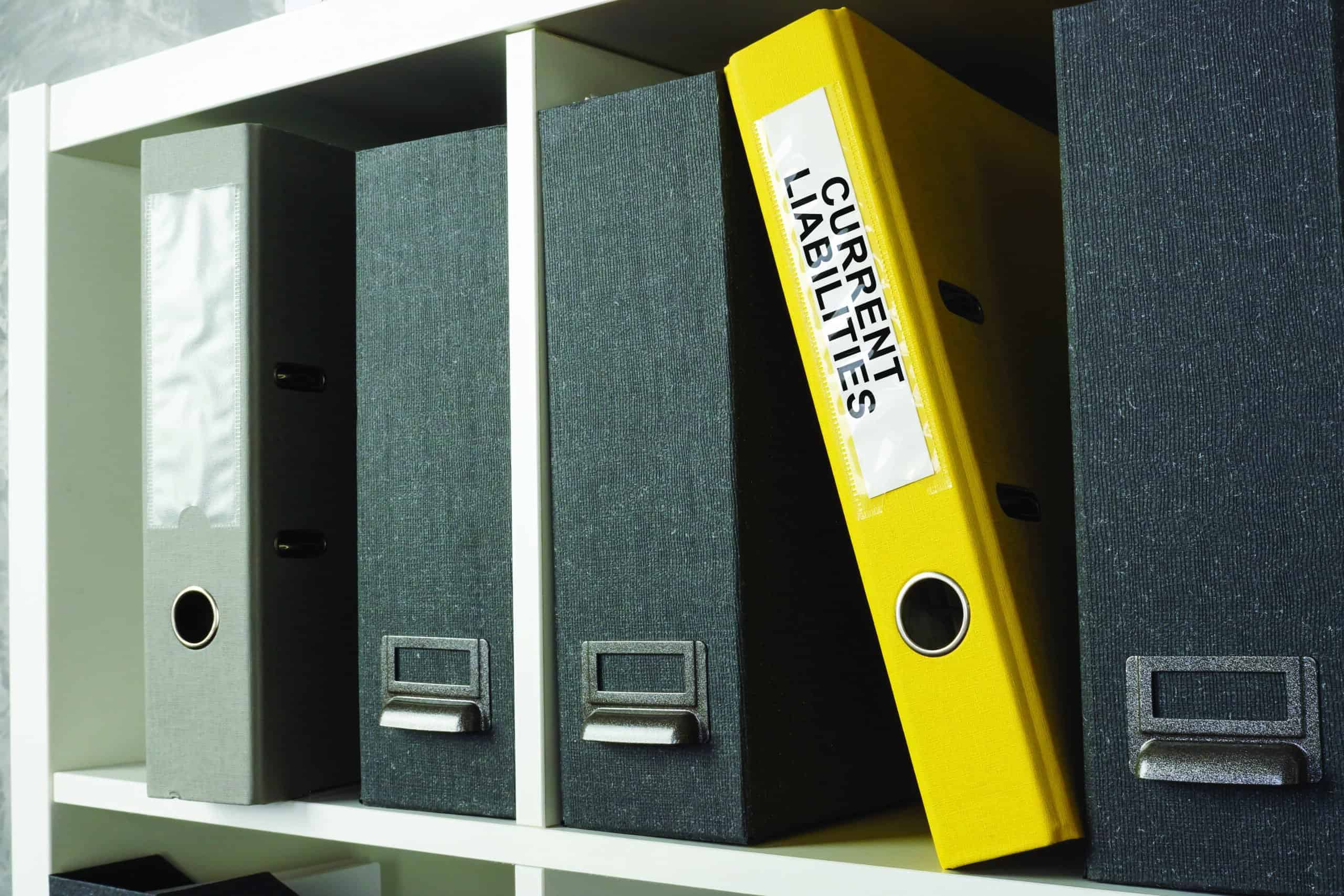 Office shelf with yellow folder current liabilities