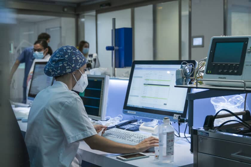 A nurse works with the computer in the ICU