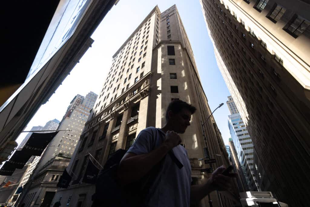 Pedestrians walk along Wall Street in New York.