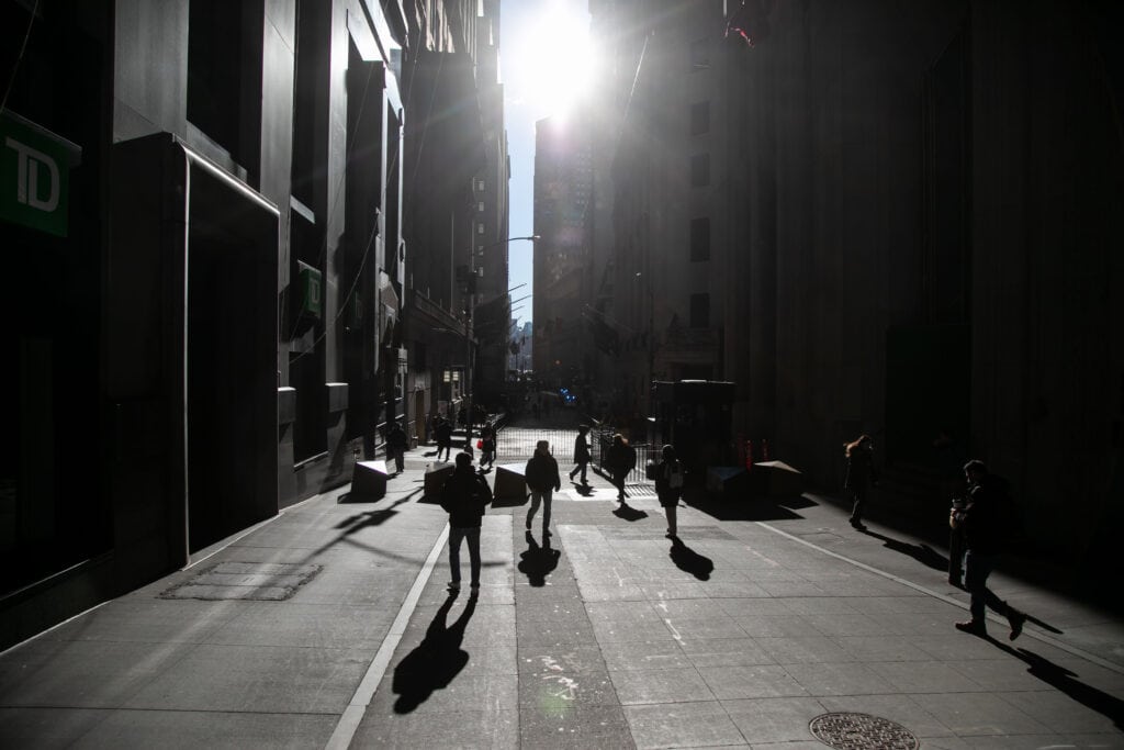 Pedestrians walk along Wall Street near the New York Stock Exchange