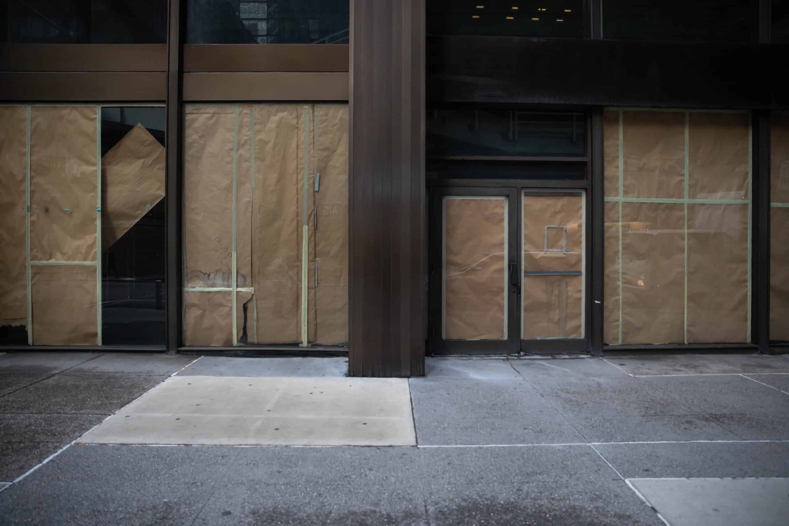 Paper covers the windows and doors of an empty retail space near the New York Stock Exchange